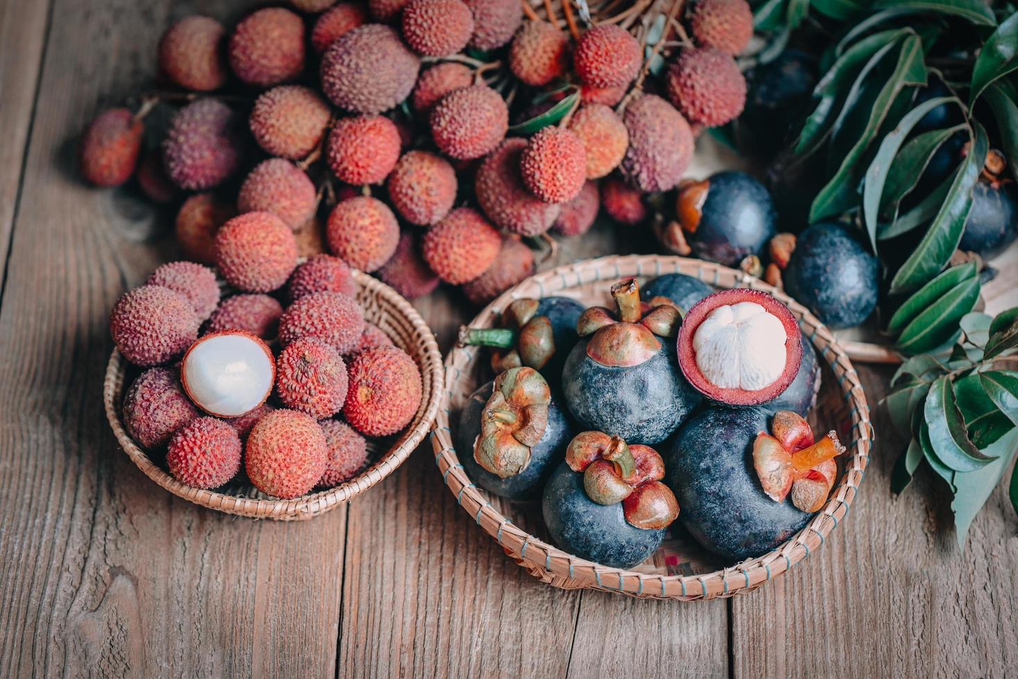 Lychee fruit and mangosteen on basket with green leaf and wooden background, fresh ripe lychee and mangosteen peeled from tree at tropical fruit Thailand in summer photo