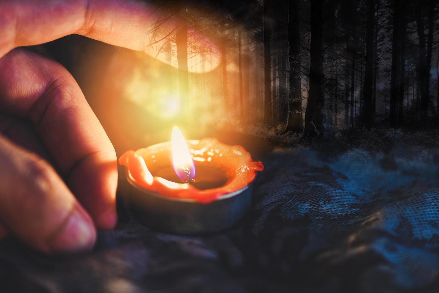 Hand with candlelight burning candle on the darkness scary forest background for Astrology Occult Magic illustration - Magic Spiritual Horoscopes and Palm reading fortune teller concept photo