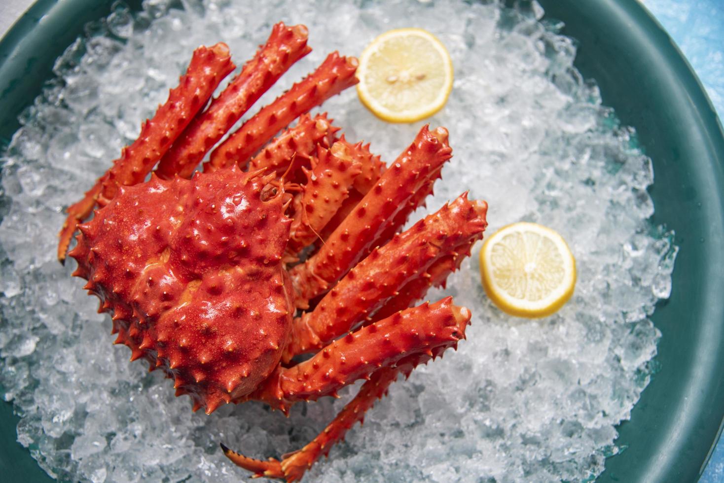 Red crab hokkaido on ice at seafood market Alaskan King Crab with lemon background photo
