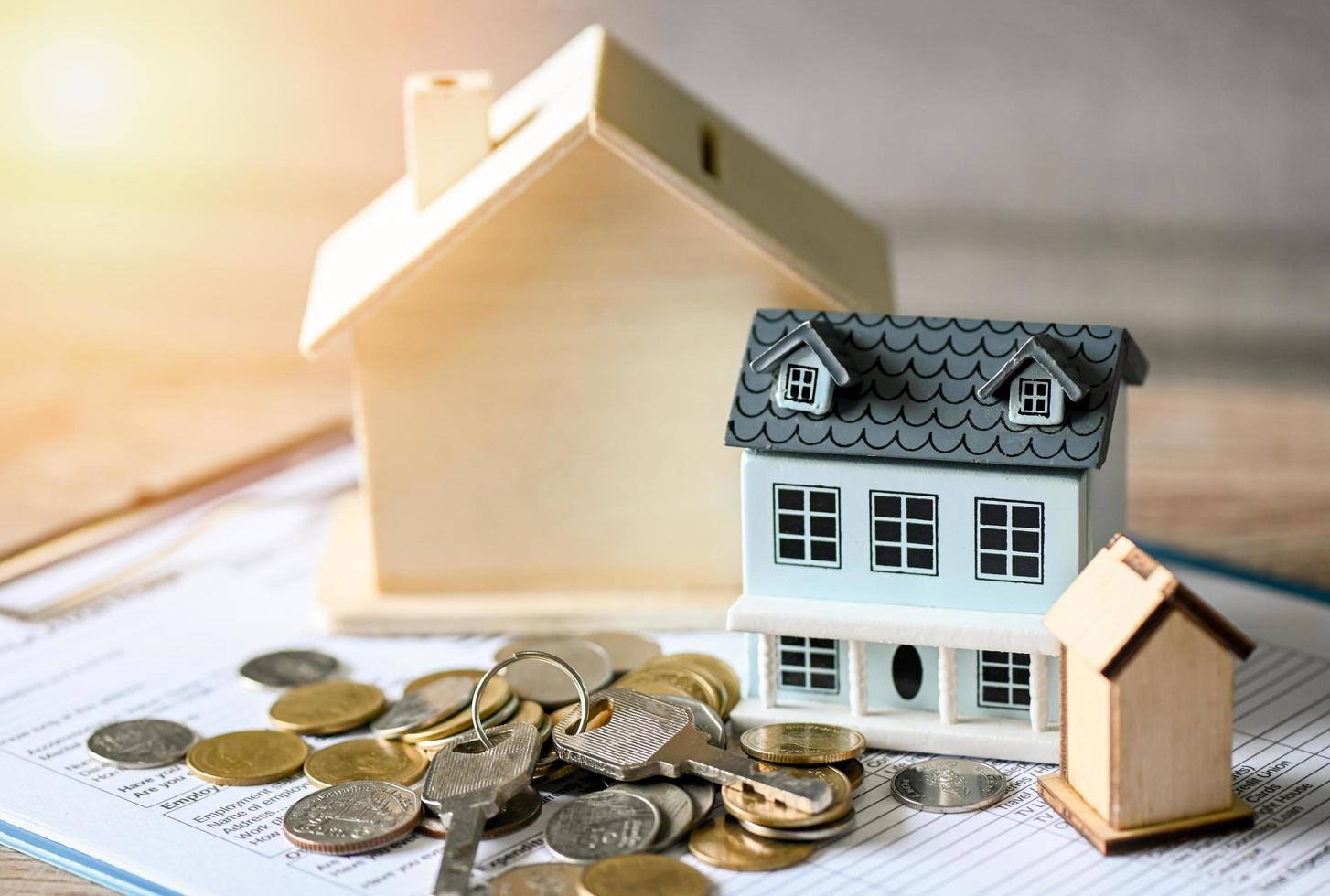 Home loan concept, Loan application form paper with money coin key and loan house model on table, Loan business finance economy commercial real estate investments concept photo