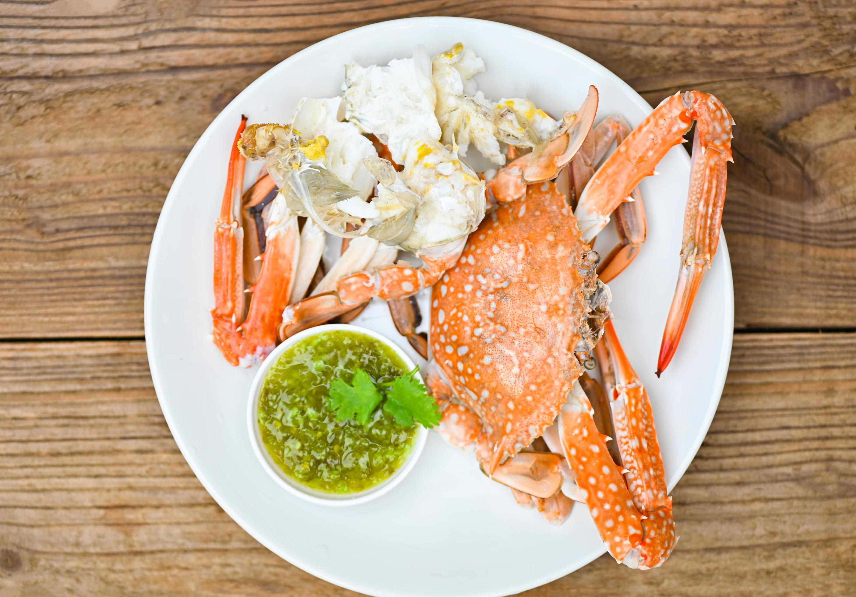seafood plate fresh crab cooking on white plate background , blue