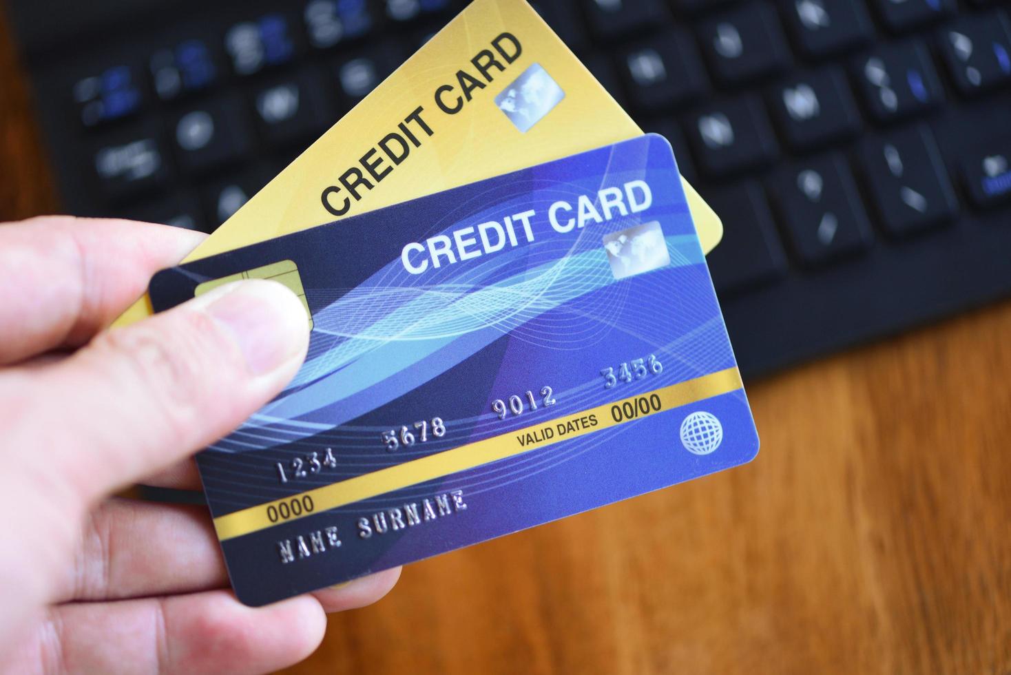 Bussiness man hands holding credit card and using laptop for online shopping in a office table keyboard background - people paying technology money wallet online payment , Credit card mockup photo