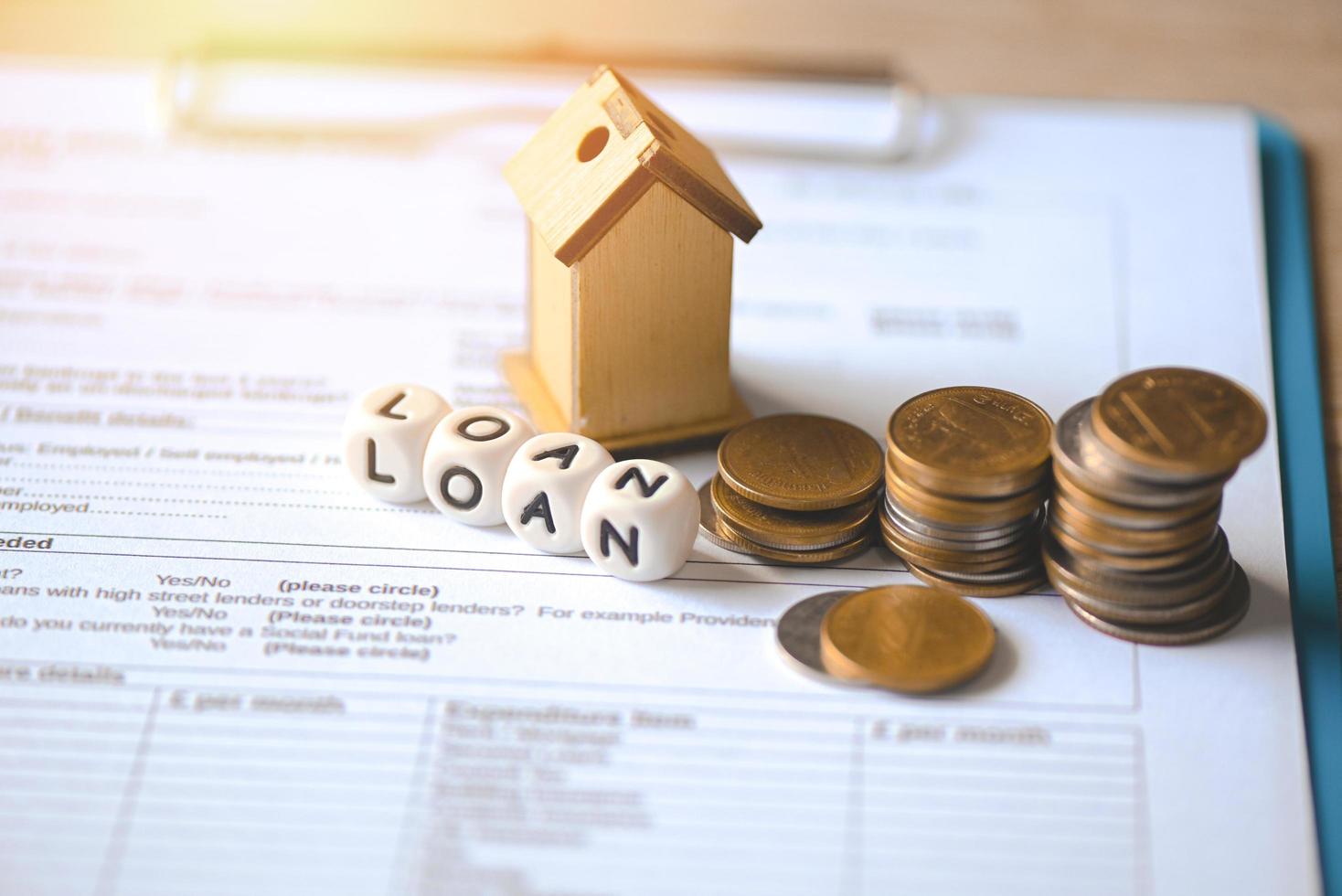 Home loan concept, Loan application form paper with money coin and loan house model on table, Loan business finance economy commercial real estate investments concept photo