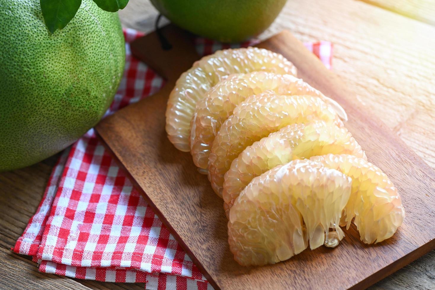 pomelo fruit on wooden background, fresh green pomelo peeled and leaf frome pomelo tree , pummelo , grapefruit in summer tropical fruit  in thailand photo