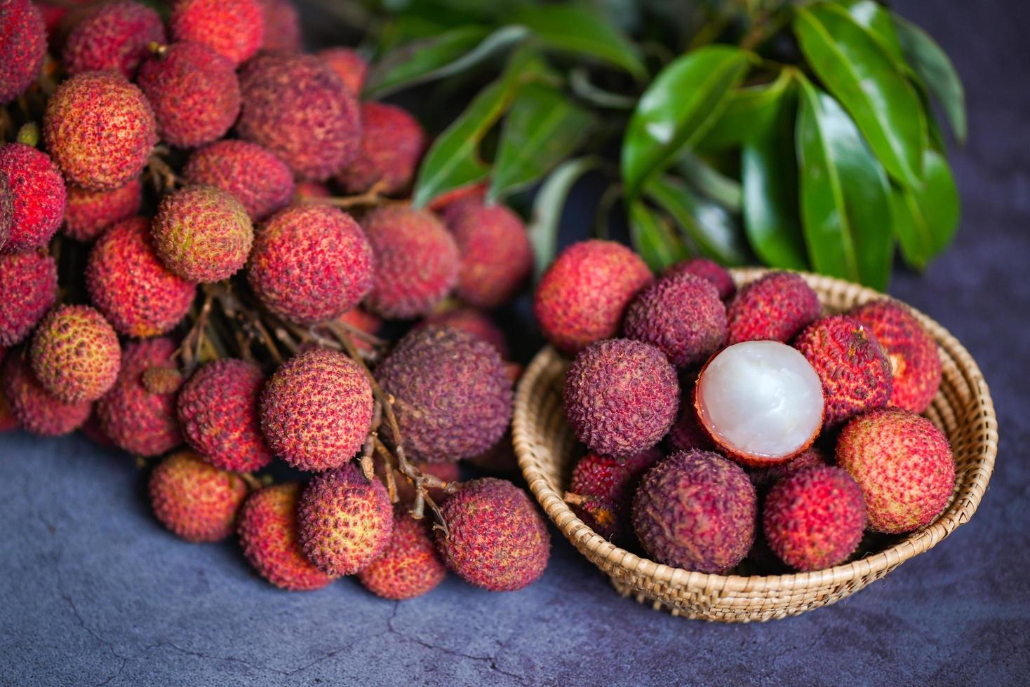 Lychee fruit with green leaf on black background, fresh ripe lychee peeled from lychee tree at tropical fruit Thailand in summer photo