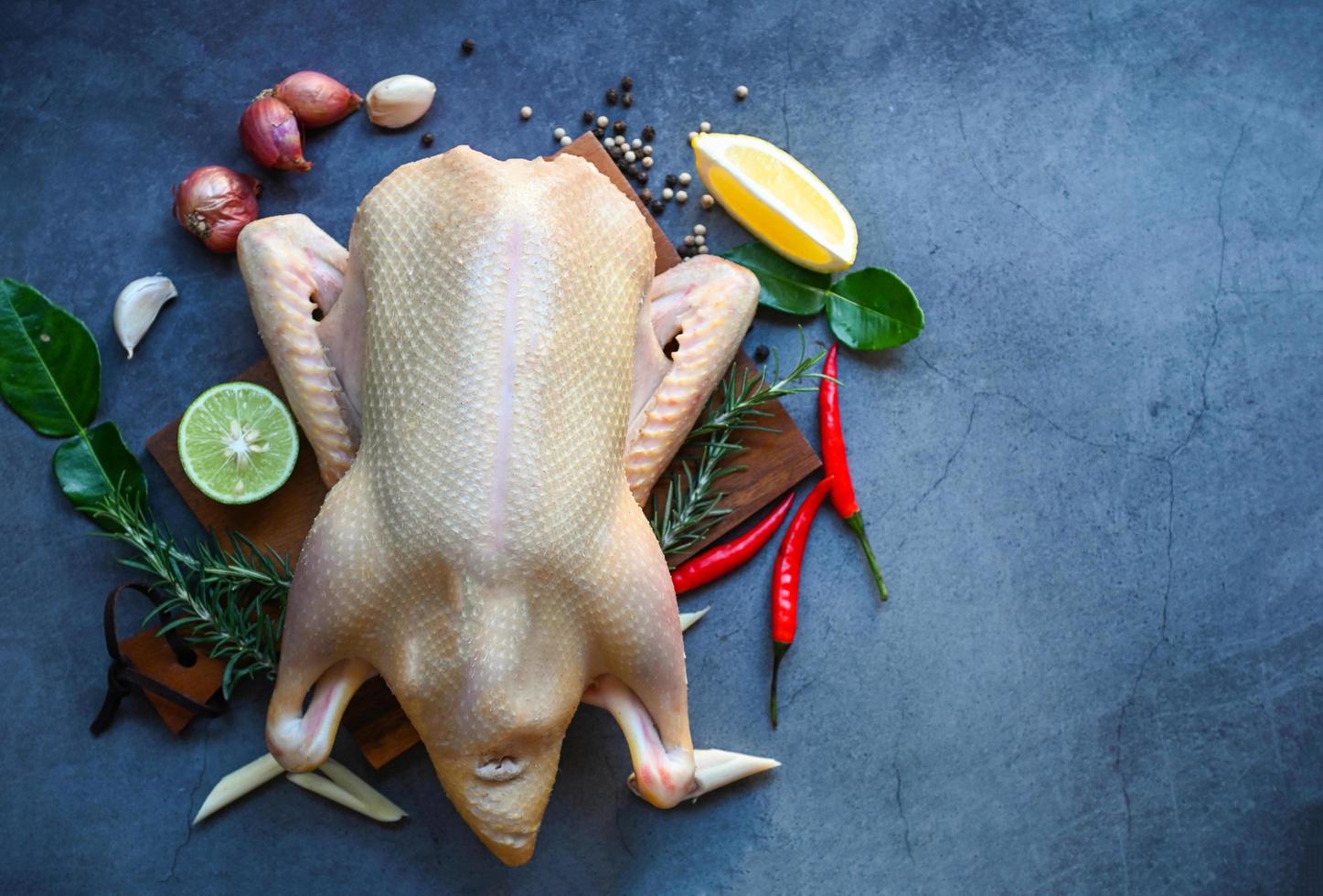 raw-duck-with-spices-ready-to-cook-on-black-background-fresh-duck