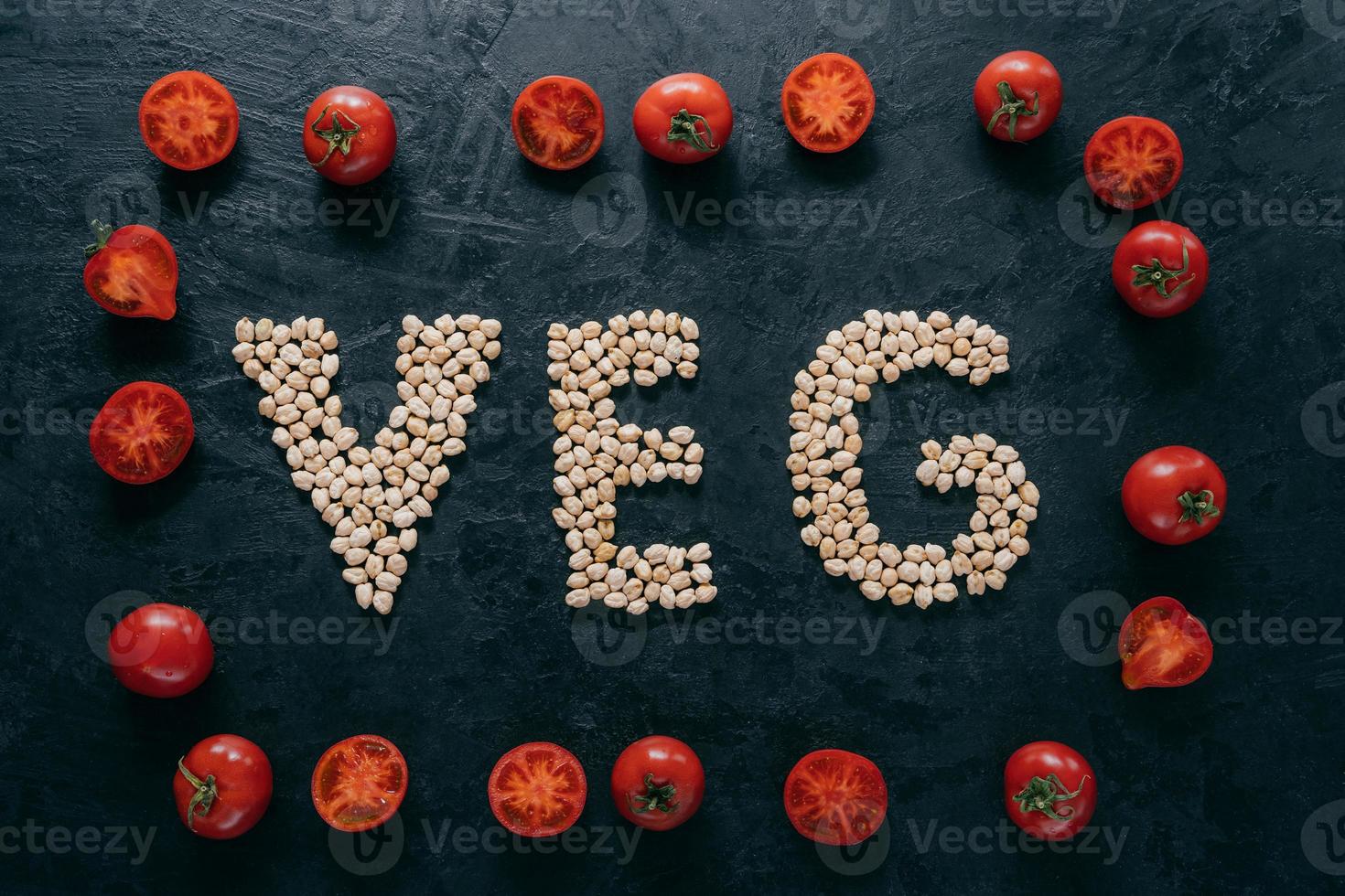 Food and nutrition concept. Horizontal shot of dry garbanzo in form of letter VEG, denoting products for vegans. Tomato frame around photo