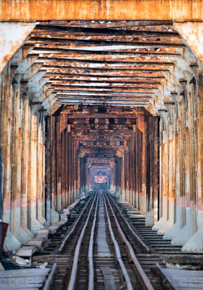 Train running on ancient railway on Long Bien bridge in Hanoi photo