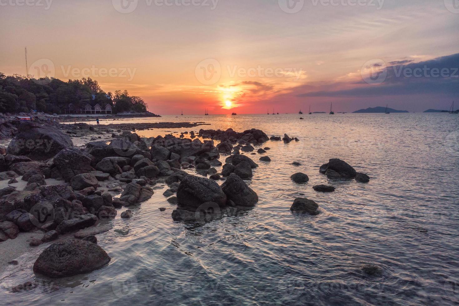 Rocks on coastline at sunset photo