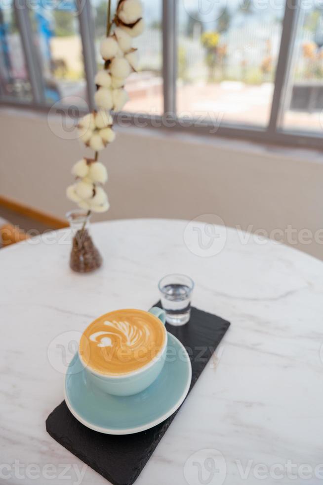 Cup of hot cappuccino coffee on table photo