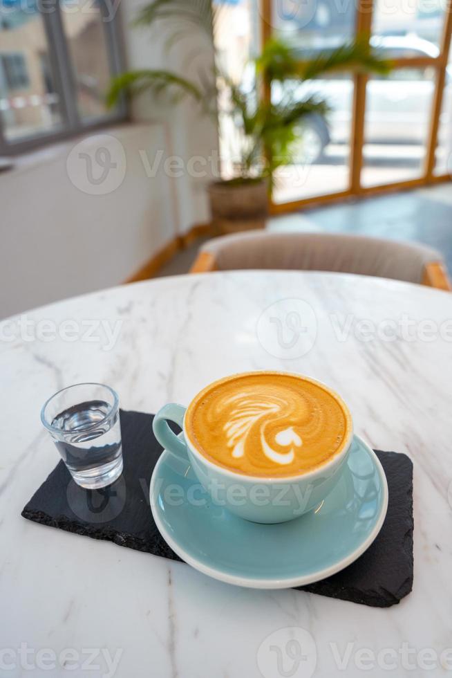 Cup of hot cappuccino coffee on table photo