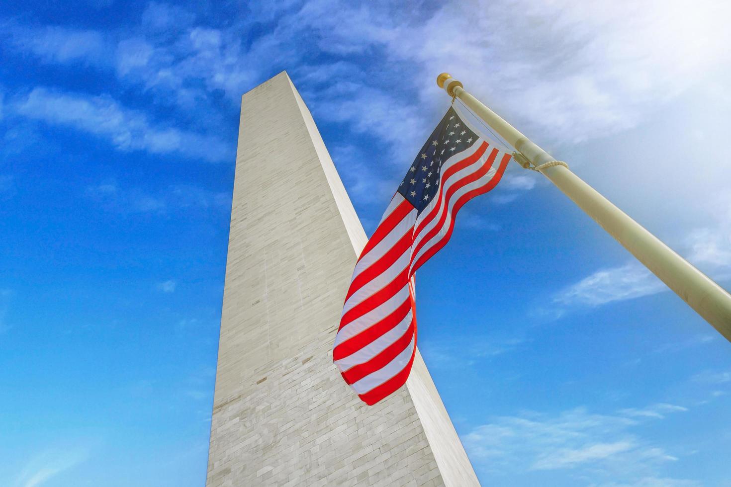 monumento a washington con la bandera de estados unidos en un día soleado. washington dc ee.uu. foto