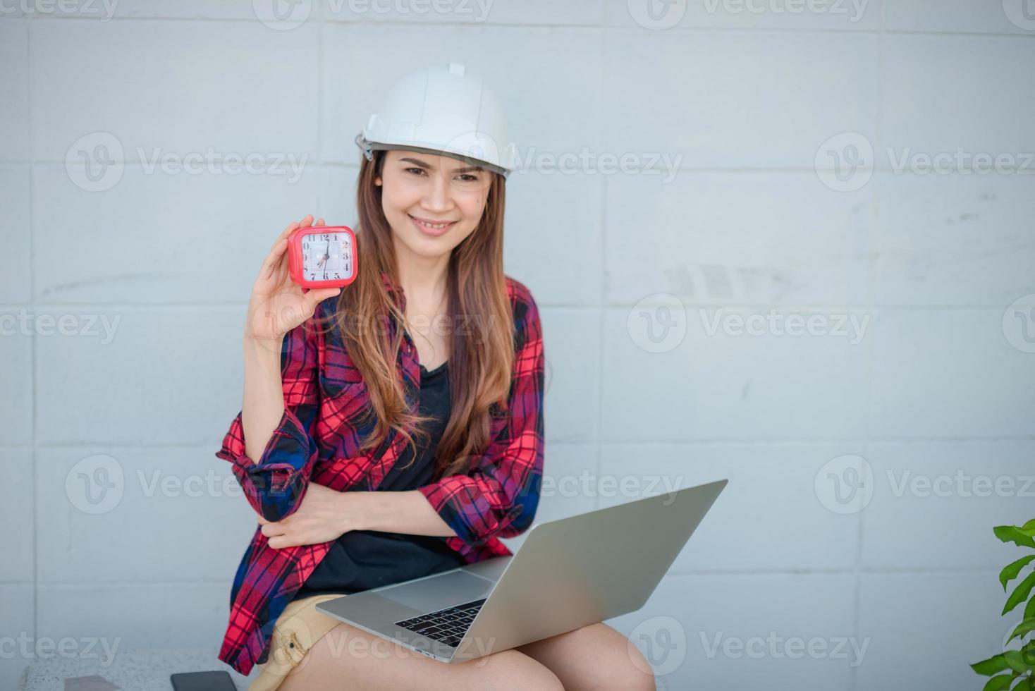 A woman works with a laptop and she has a watch for telling the time. photo