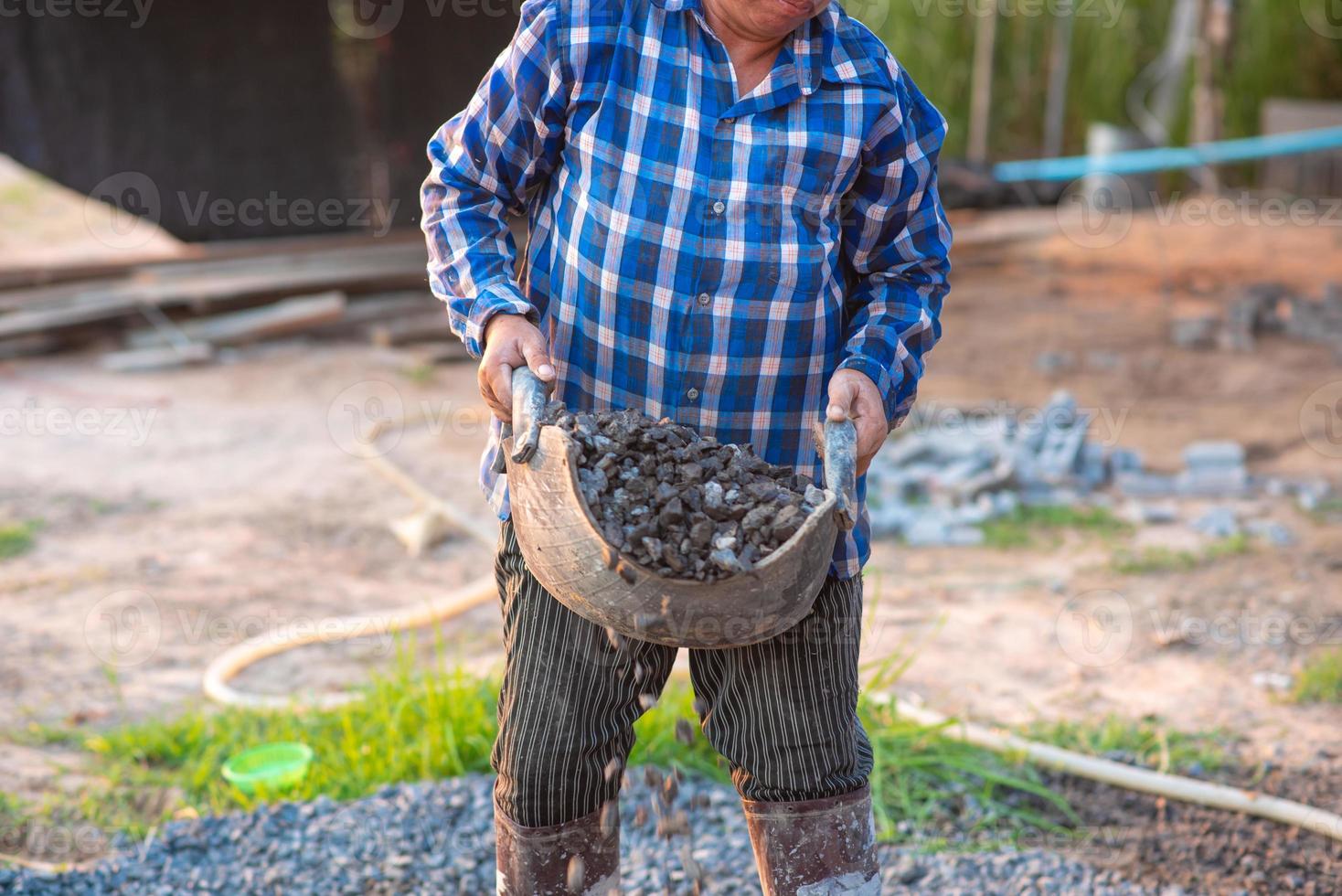 los trabajadores de la construcción llevan piedras para mezclar con cemento. foto