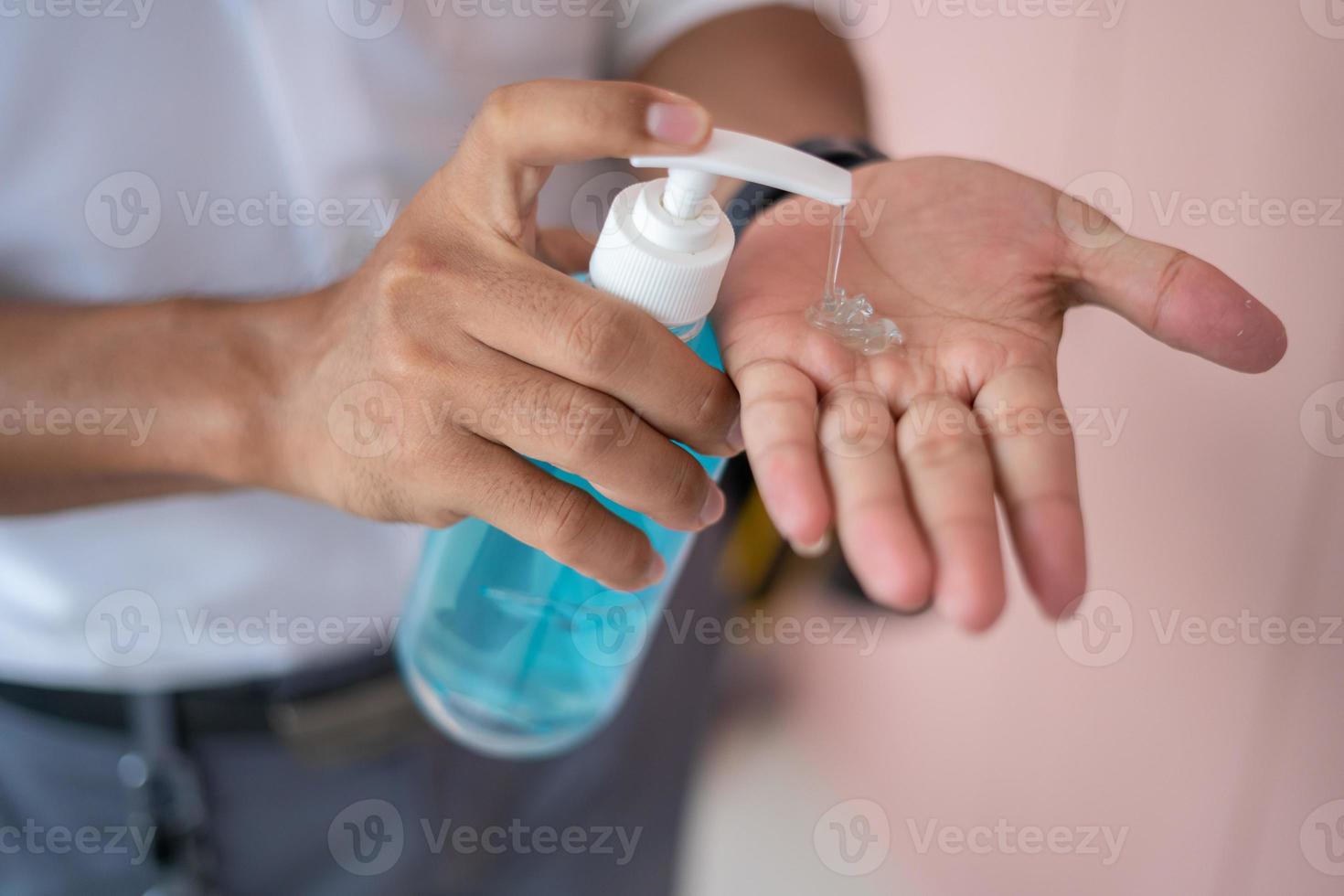 las manos de los hombres usan desinfectante de manos, gel de lavado de manos, bomba dispensadora para prevenir enfermedades transmisibles. foto