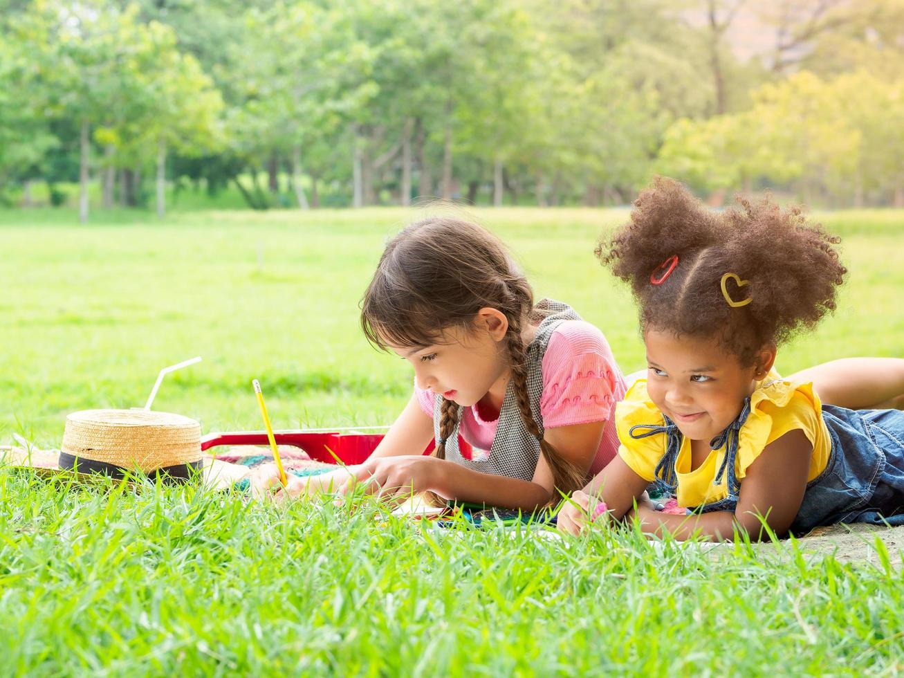 un grupo de niños pequeños de muchas nacionalidades juegan y aprenden fuera de la escuela foto