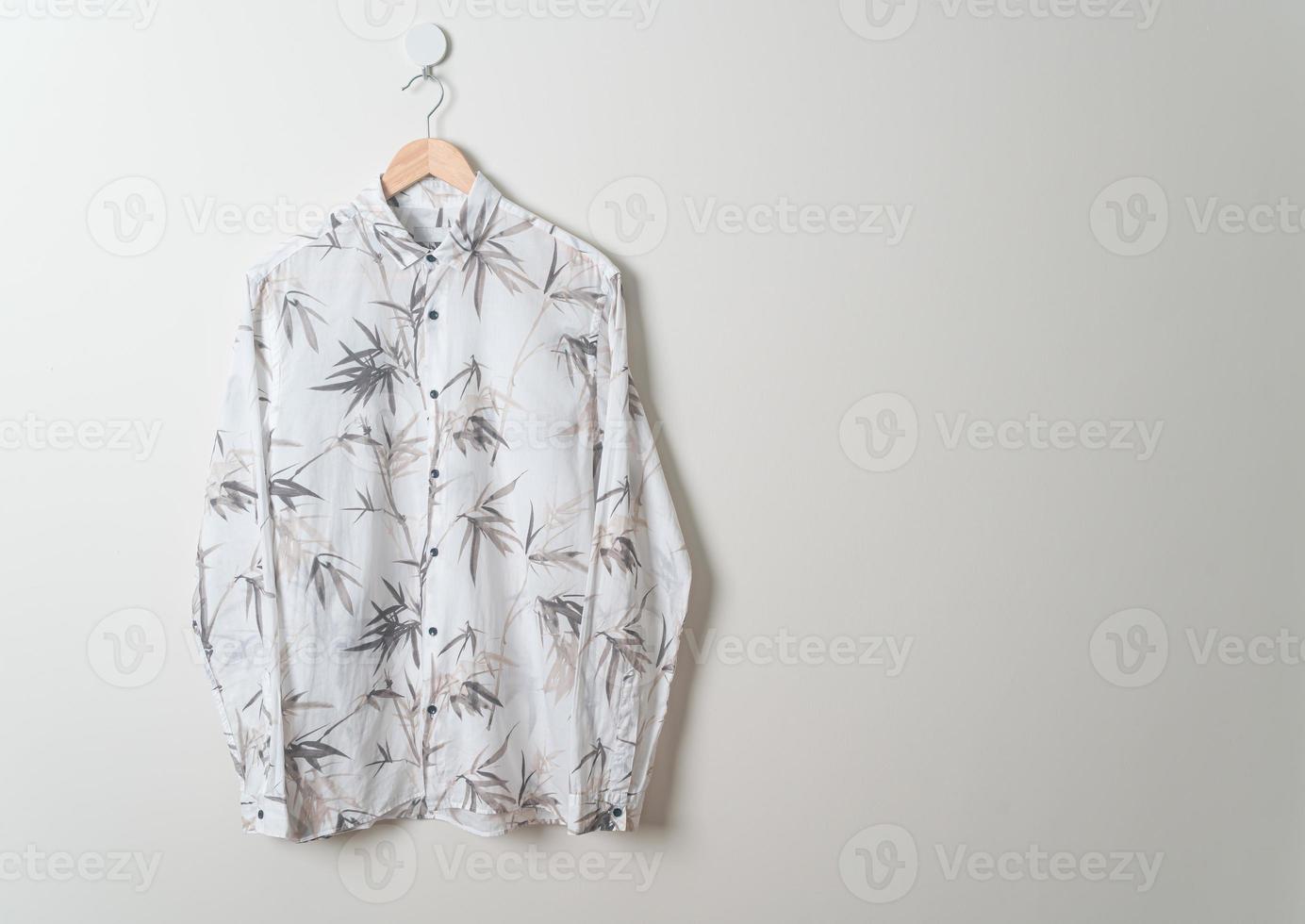 hanging shirt with wood hanger on wall photo