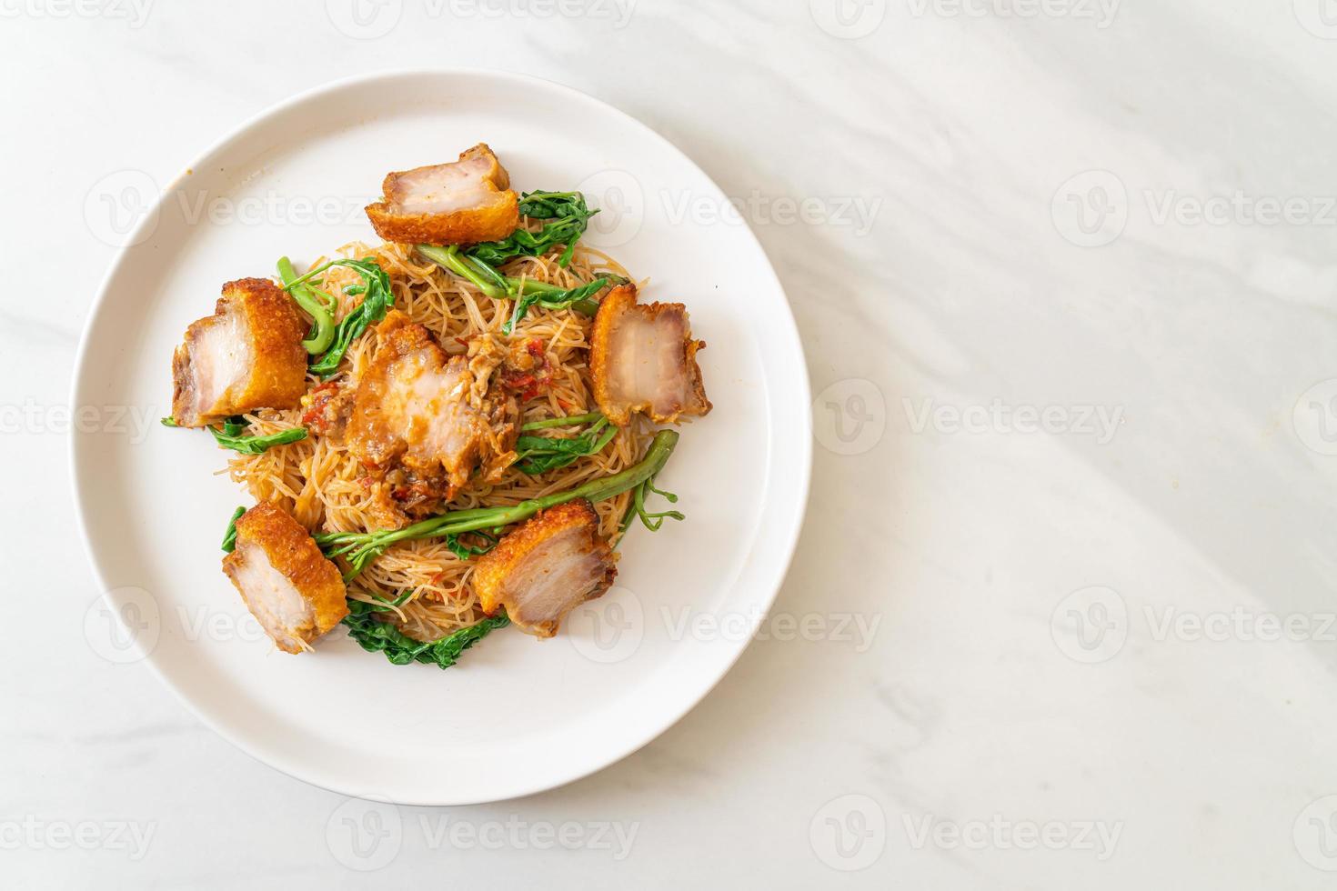 Fideos de arroz salteados y mimosa de agua con panceta de cerdo crujiente foto