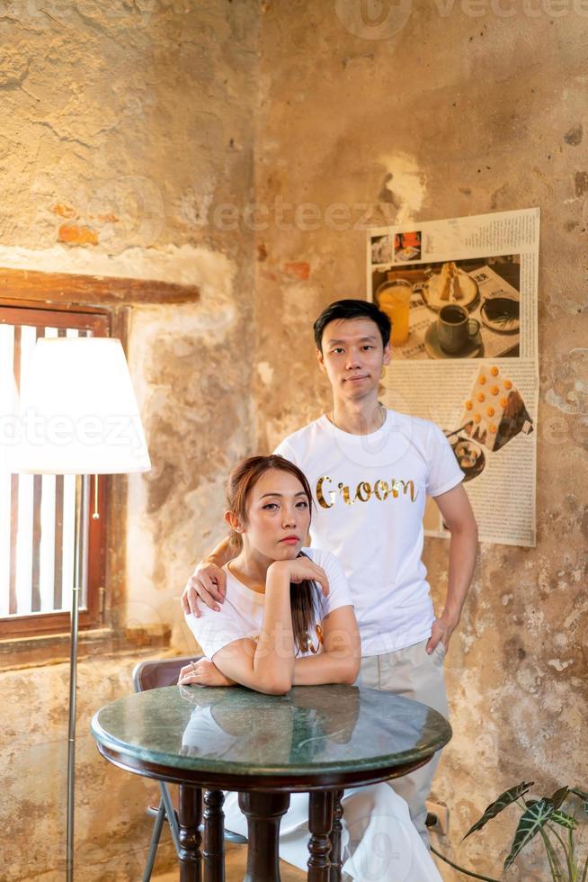 Happy young Asian couple in bride and groom t-shirt photo