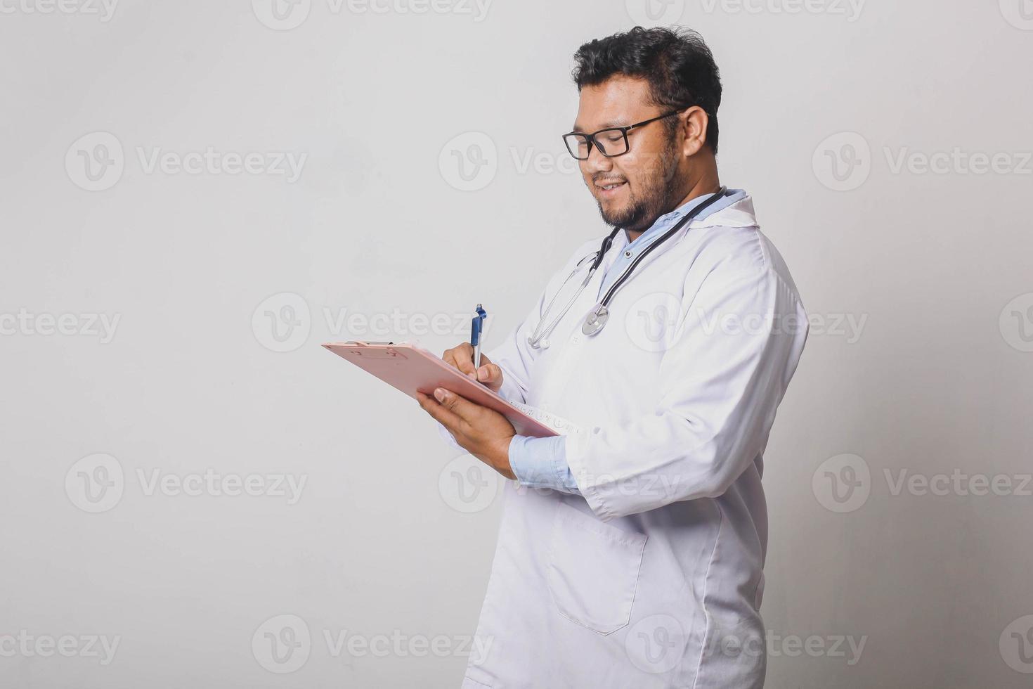 alegre médico varón tomando notas médicas aislado sobre fondo blanco con espacio de copia foto