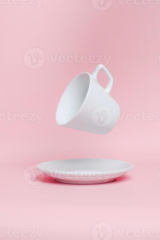 Classic white cup and levitation front view on pink background in style of blank template mockup. Empty glass or drink cup  mockup photo