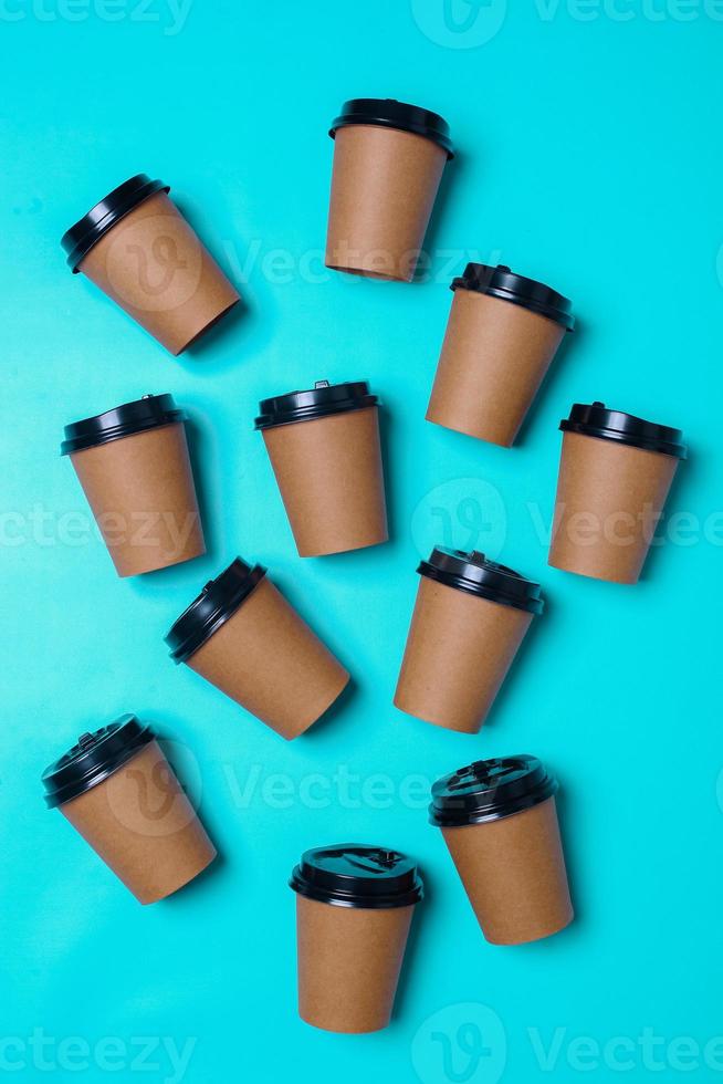 Paper cups randomly arranged on blue background. Realistic set mock up for branding,  template for your design, presentation, promo, ad. photo