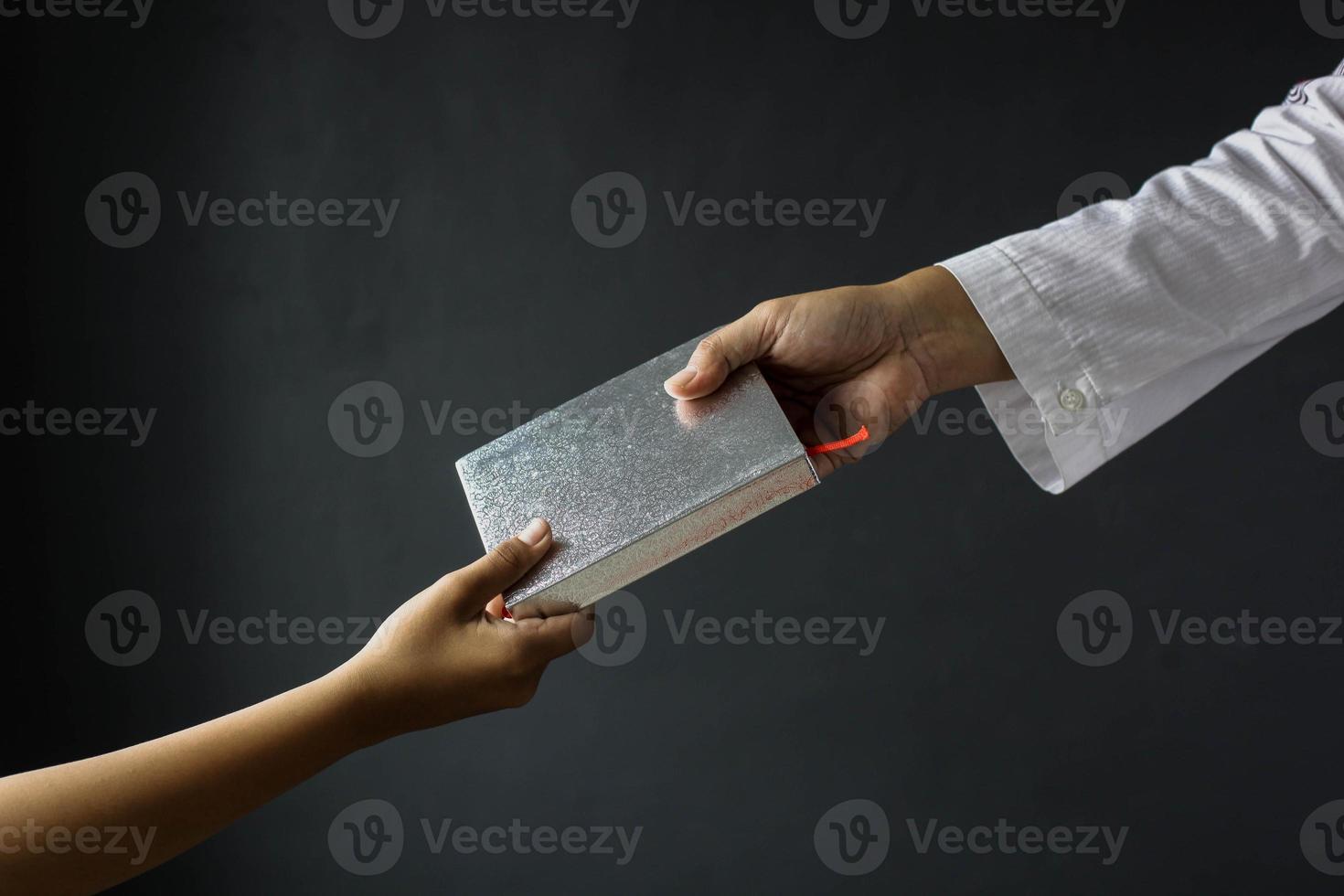 Islamic background concept. Two muslim hands holding quran isolated on gray background photo