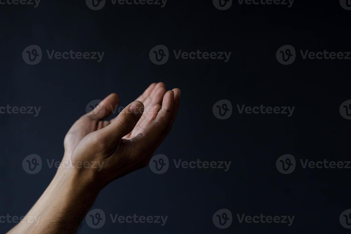 Muslim hands praying isolated on black background with copy space. ramadan kareem concept photo