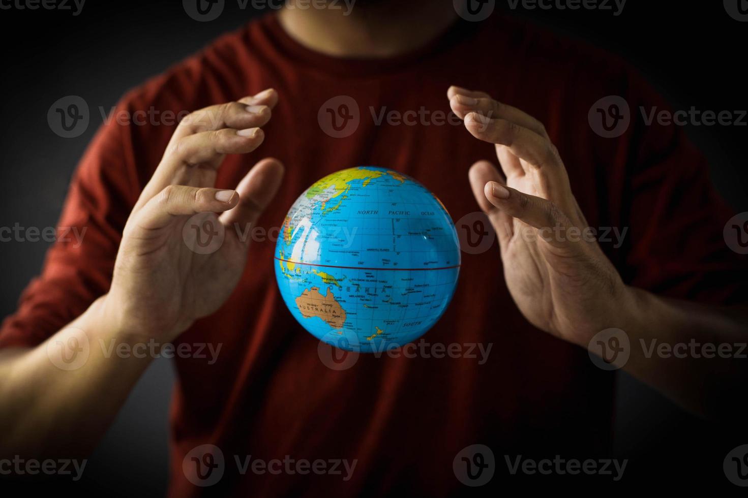 un globo flota entre las manos sobre el pecho de un hombre. concepto del día de la tierra con foto de tono bajo