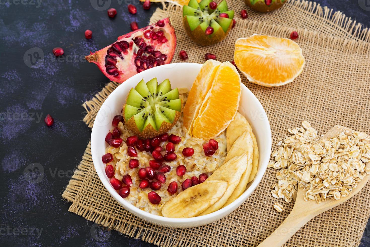 Healthy breakfast. Oatmeal with fruit on dark background photo