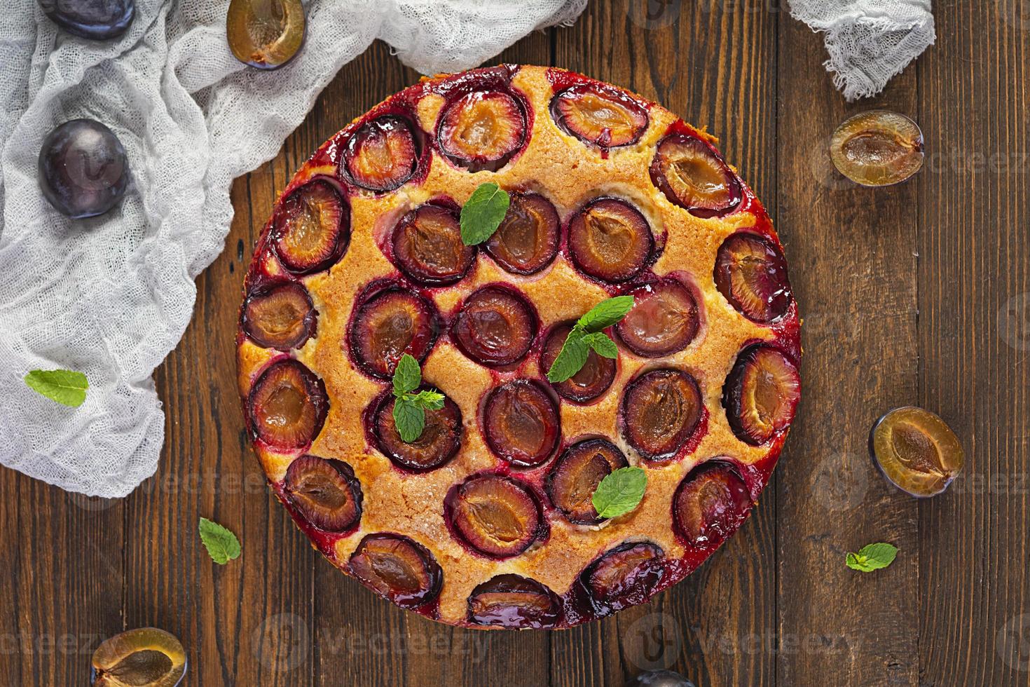 Delicious homemade plum pie on rustic background. Top view photo