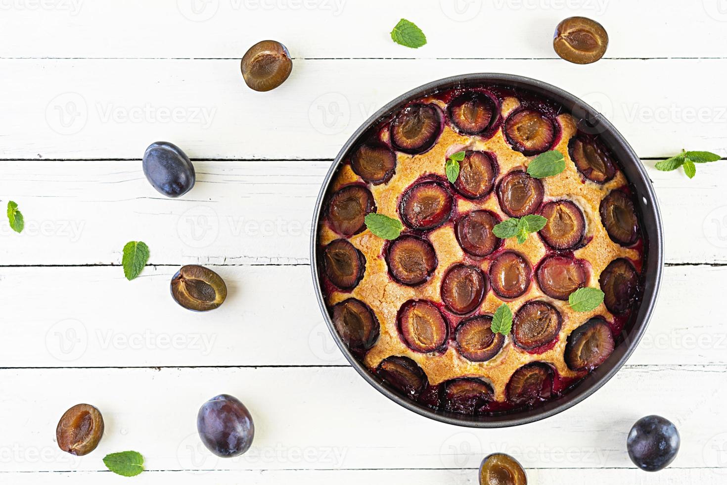 Delicious homemade plum pie on white background. Top view photo