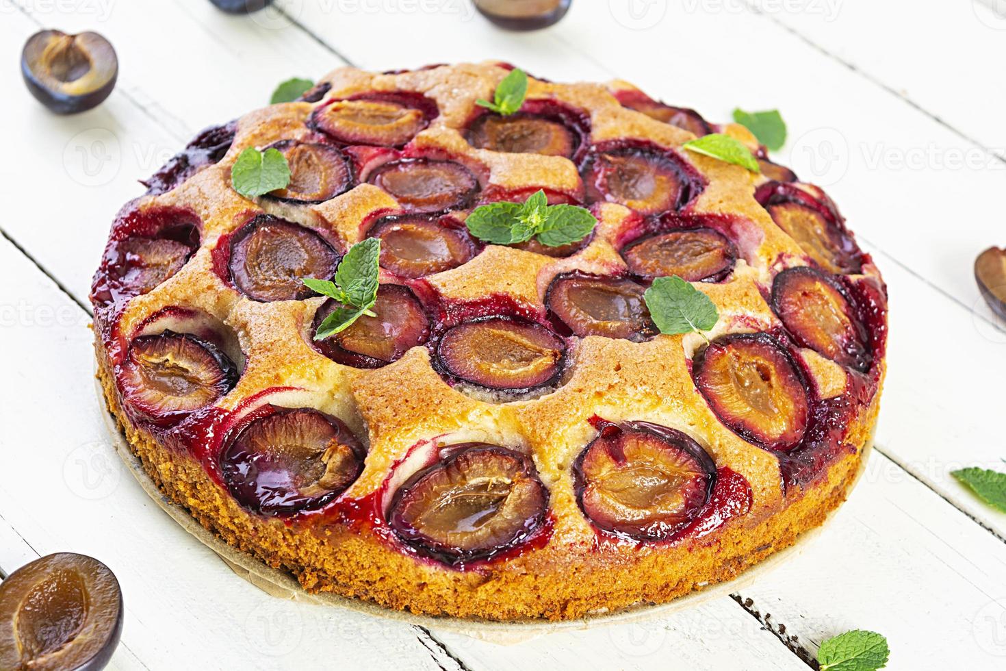 Delicious homemade plum pie on white background photo