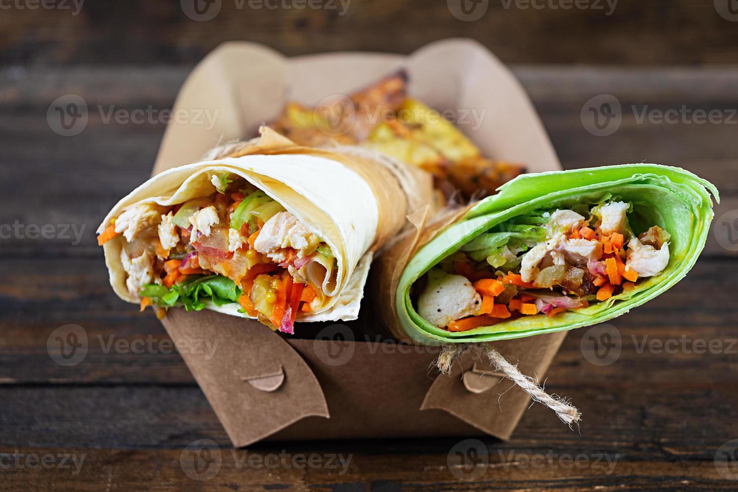 delicioso sándwich de shawarma con pollo y patata sobre fondo de madera foto