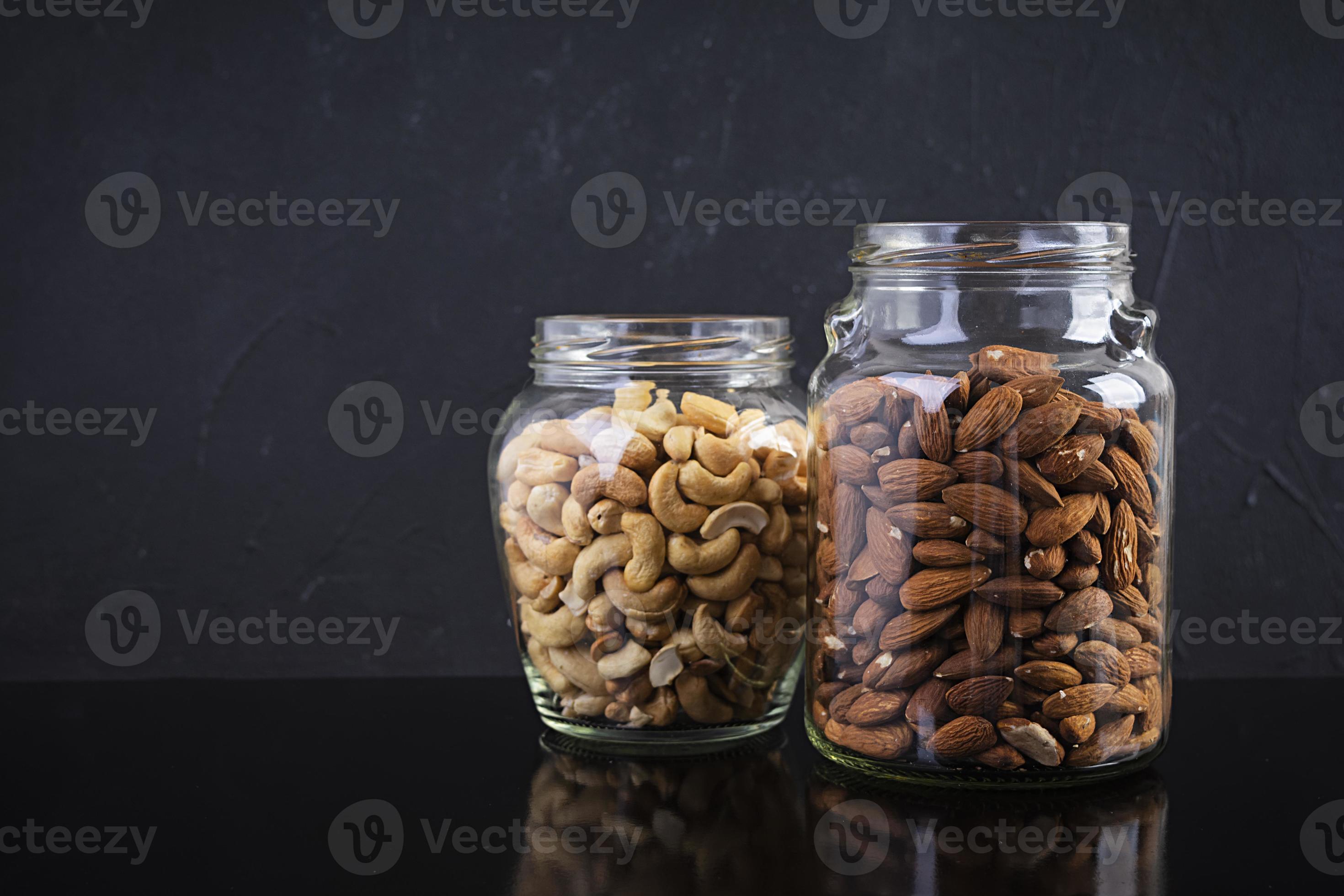 Cashew and almonds nuts in a jar. Set of nuts isolated on dark