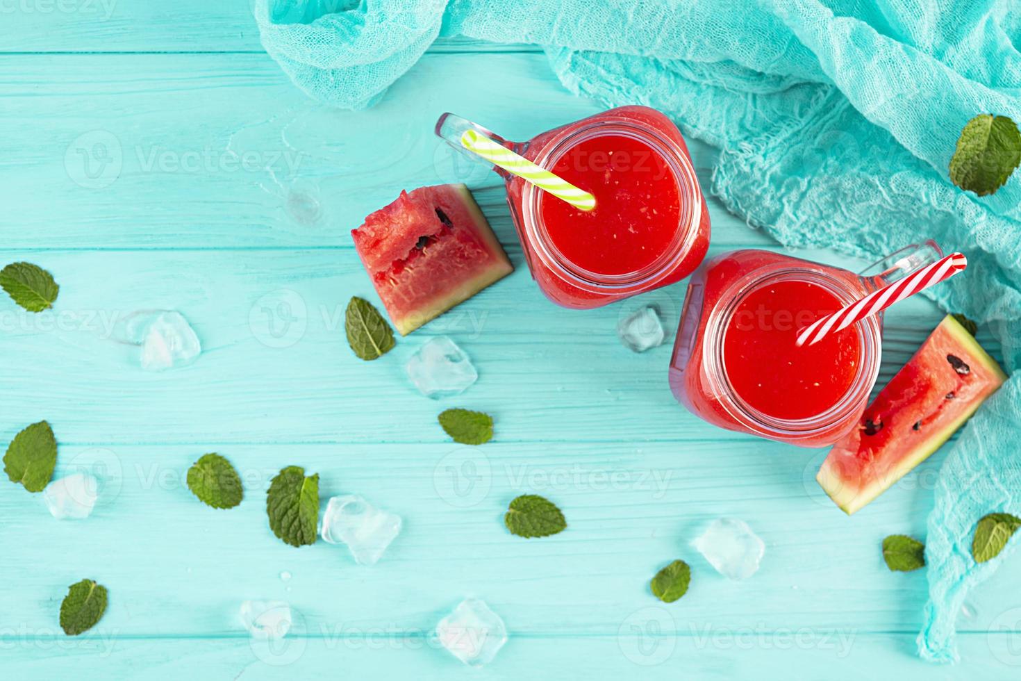 delicioso batido de sandía fresco con hielo sobre fondo azul foto