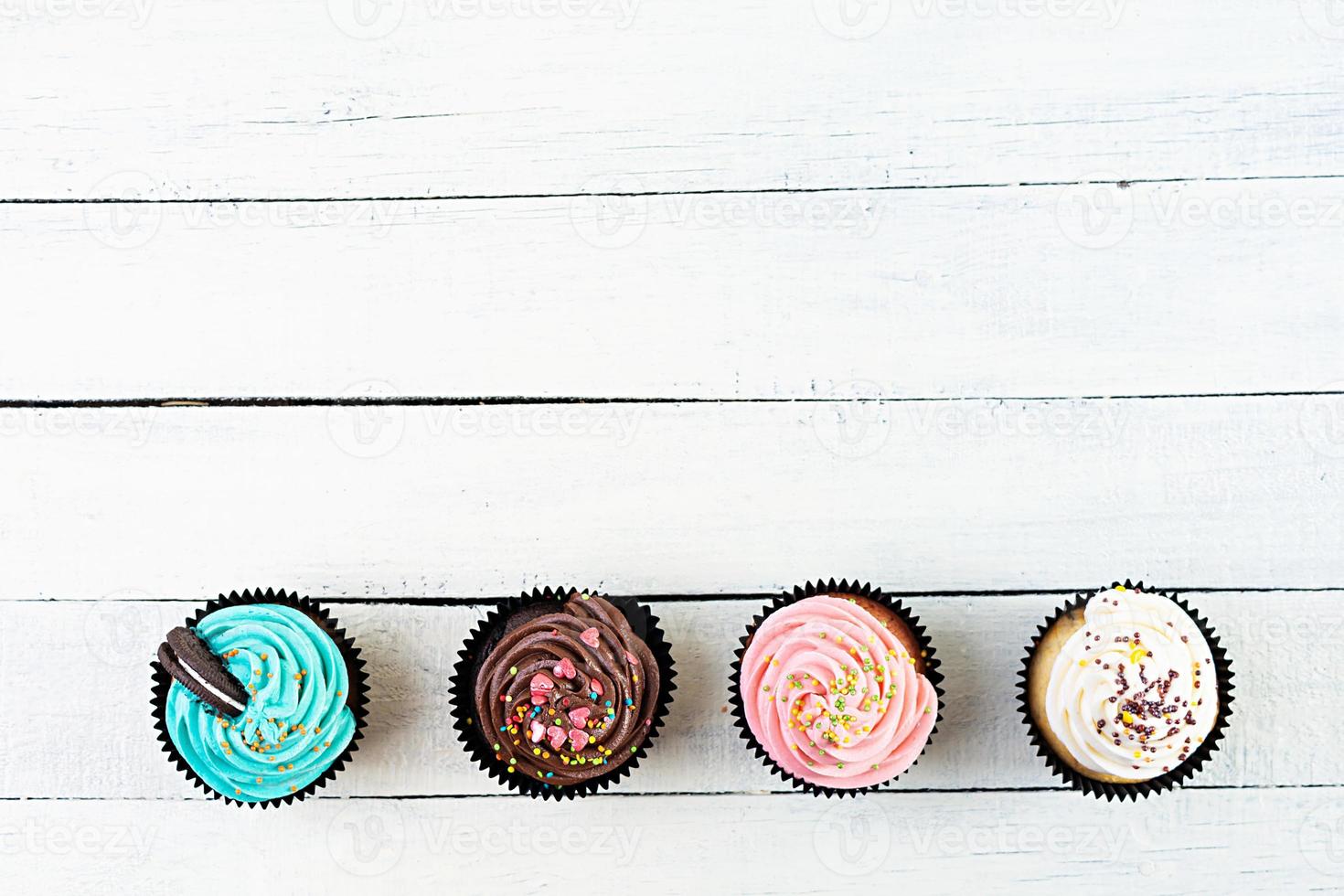 Tasty colorful cupcakes isolated on wooden background. Delicious cupcake photo