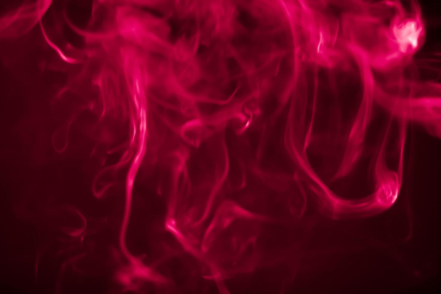 Red smoke in a dark room in a black background photo