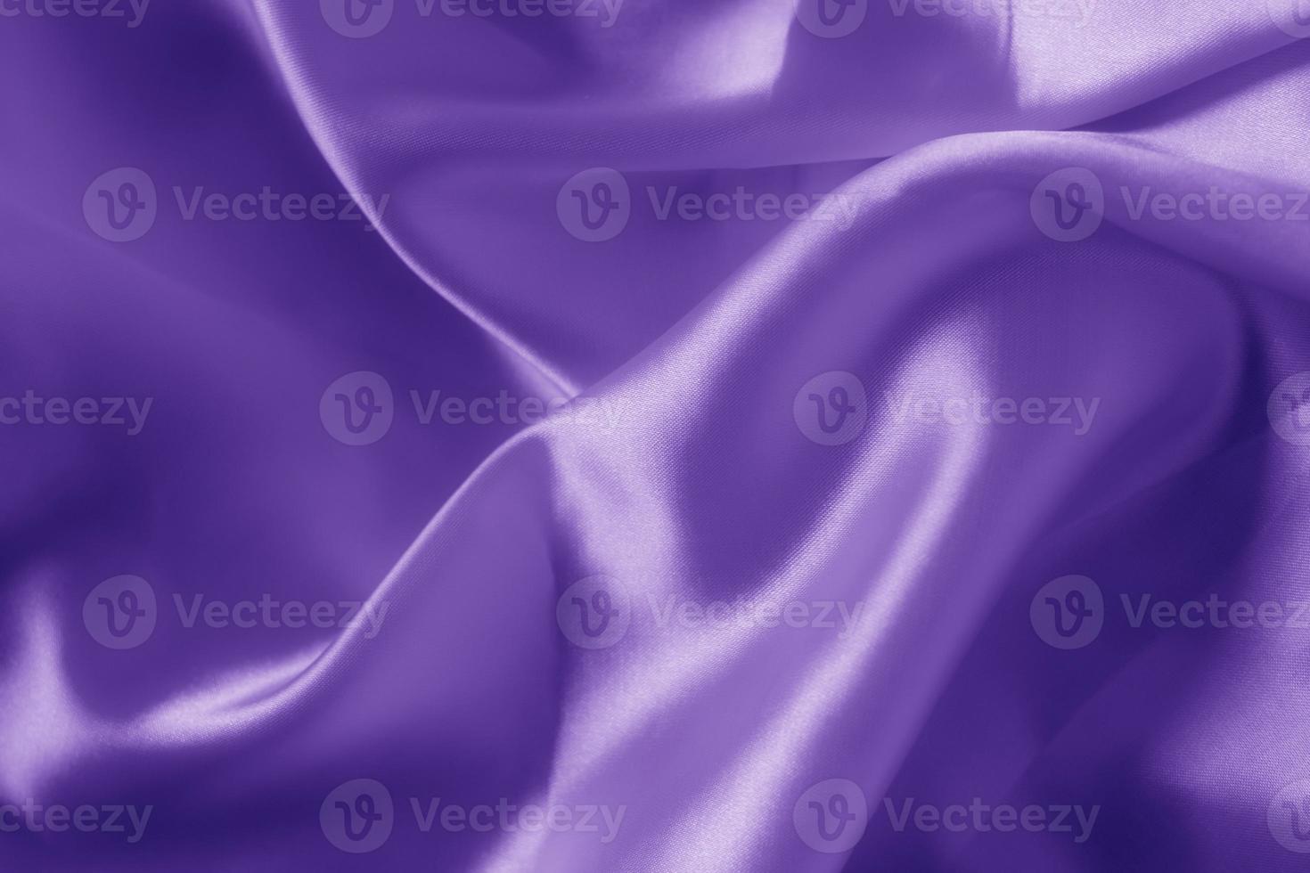 The texture of the proton purple cloth with waves and shrugs. Shiny fabric. photo