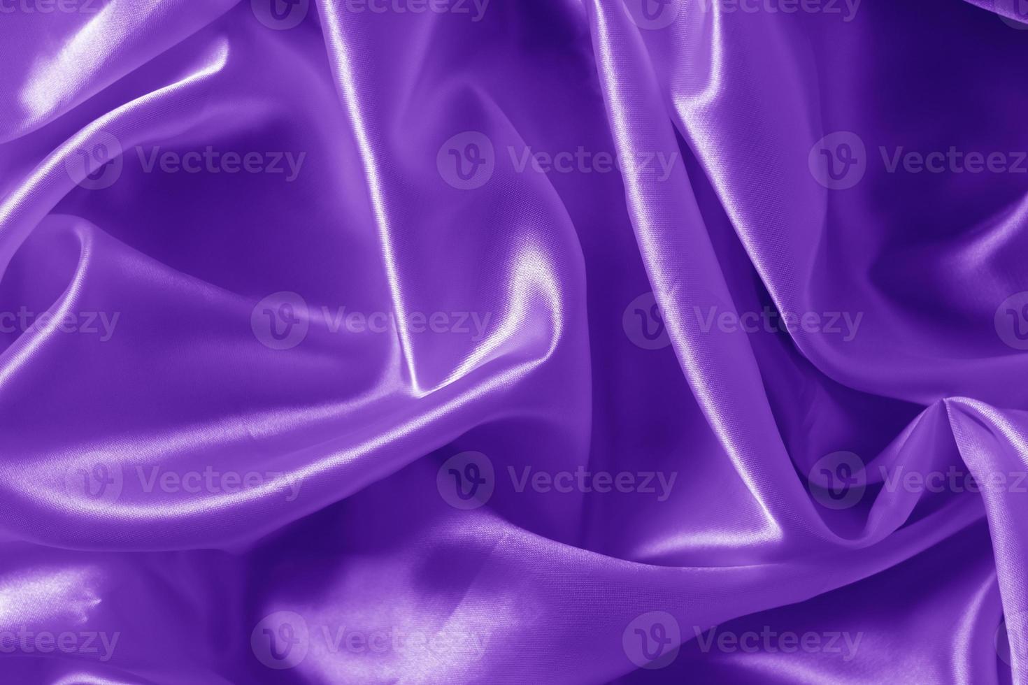 The texture of the proton purple cloth with waves and shrugs. Shiny fabric. photo