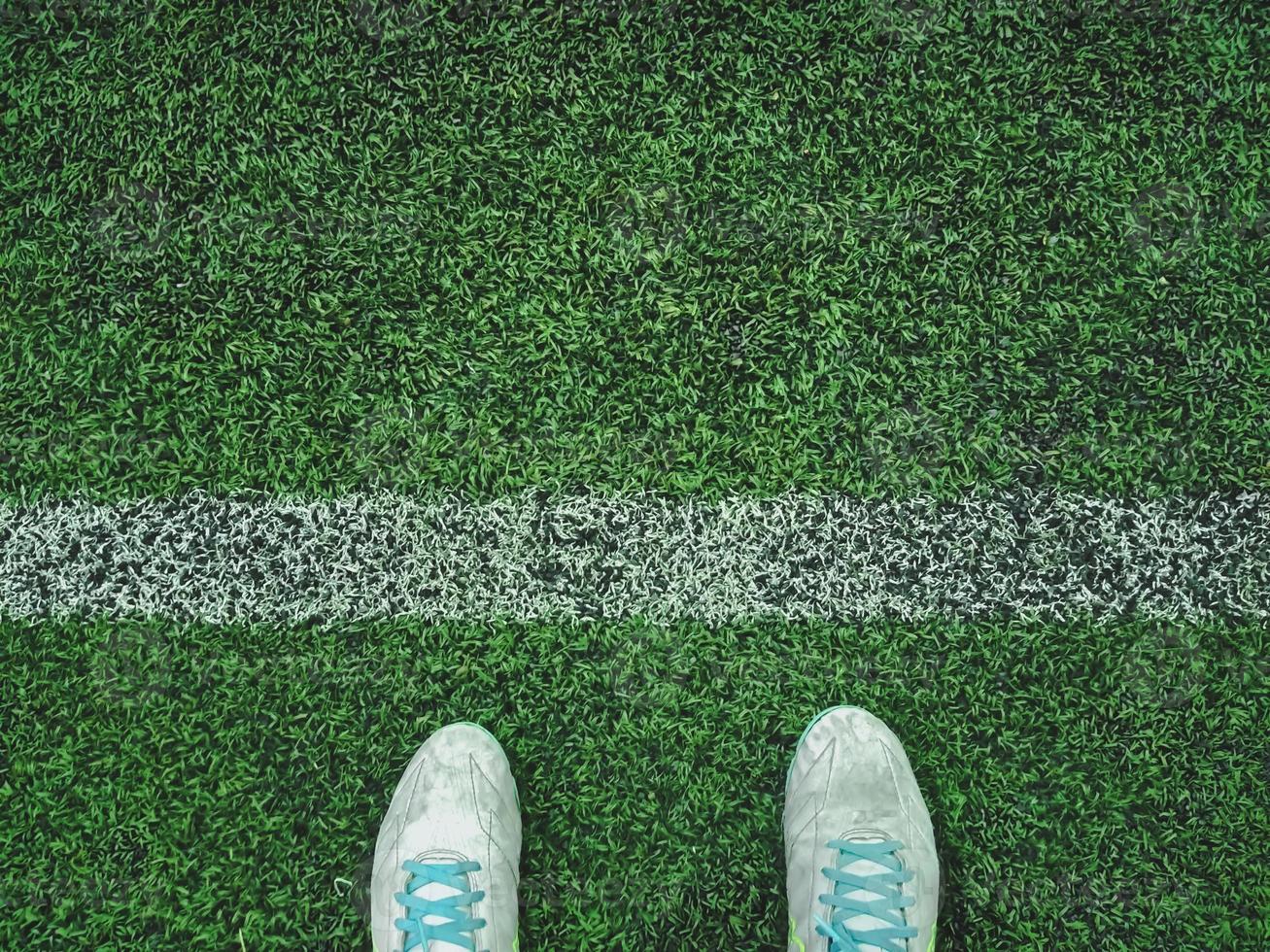 Artificial grass with shoes and white lines photo
