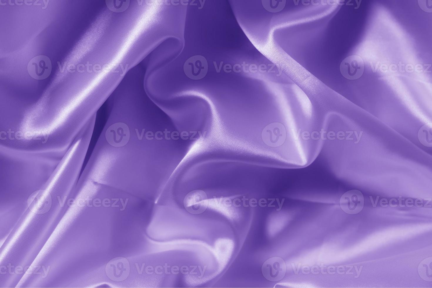 The texture of the proton purple cloth with waves and shrugs. Shiny fabric. photo