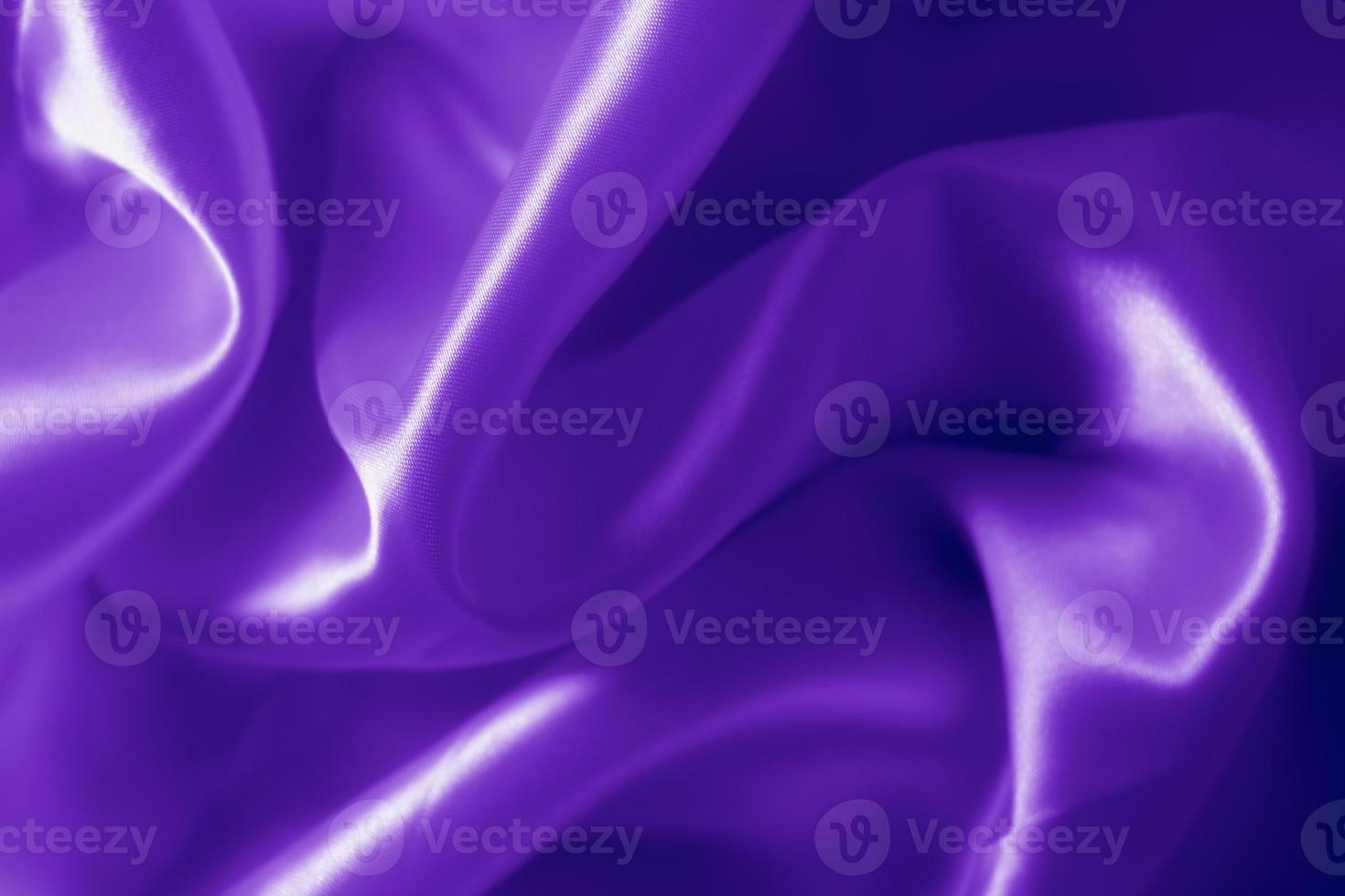 The texture of the proton purple cloth with waves and shrugs. Shiny fabric. photo