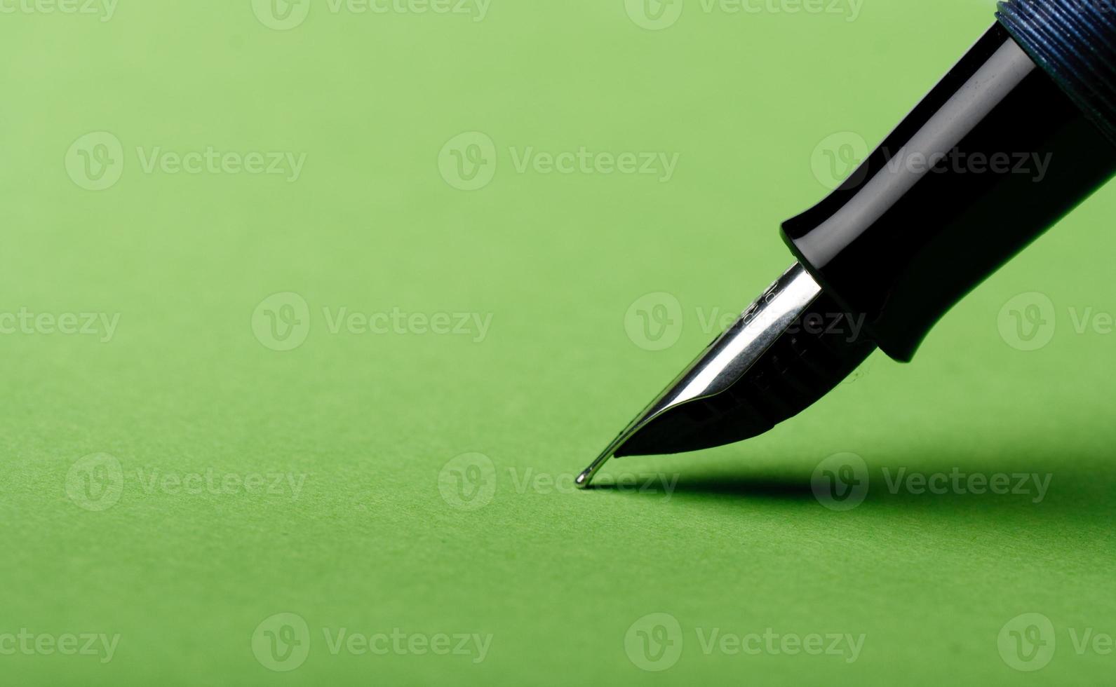 Fountain pen closeup on green background photo