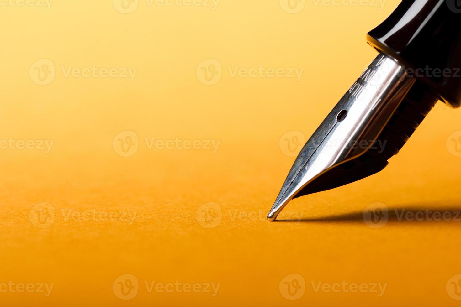 Fountain pen on yellow background photo