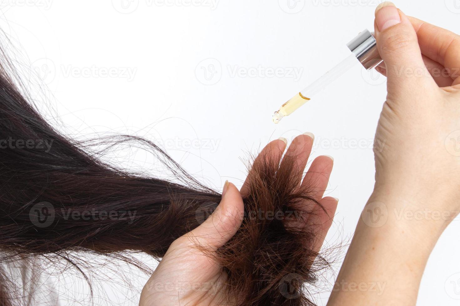 A young woman with long hair and a pipette in her hand. Hair treatment and care photo