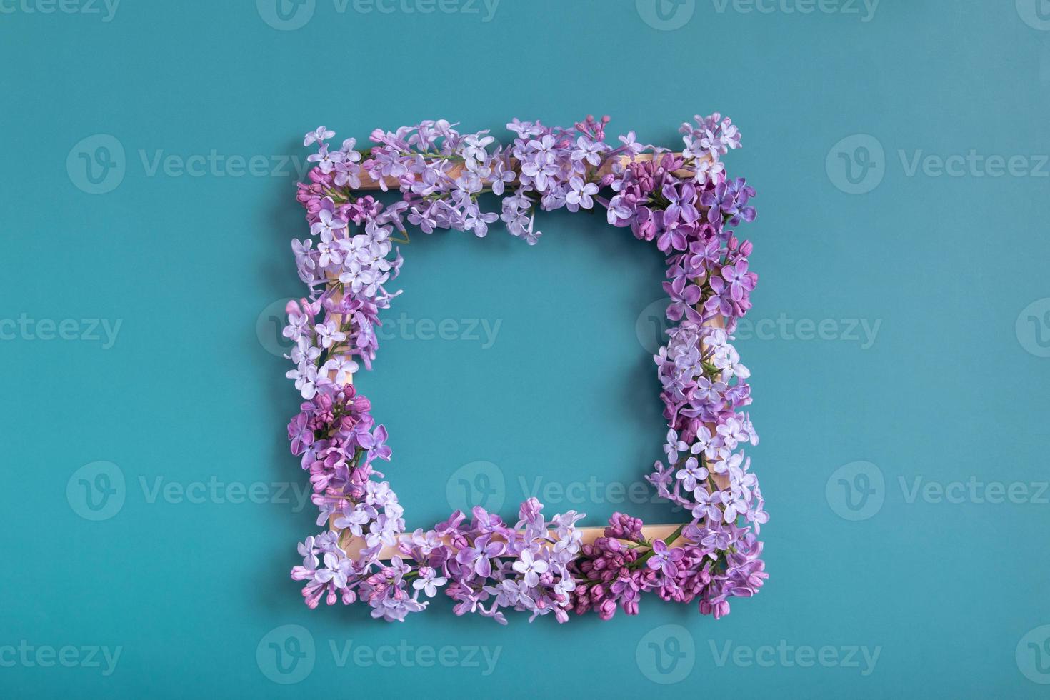 Summer or spring composition on a turquoise background. Lilac flowers square with copy space top view. Summer, spring floral concept photo