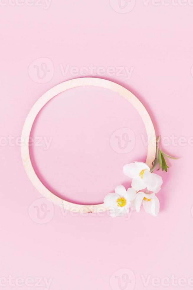 Summer or spring composition on a pink background. Wooden frame with anemone flowers with copy space. Summer, spring floral concept photo