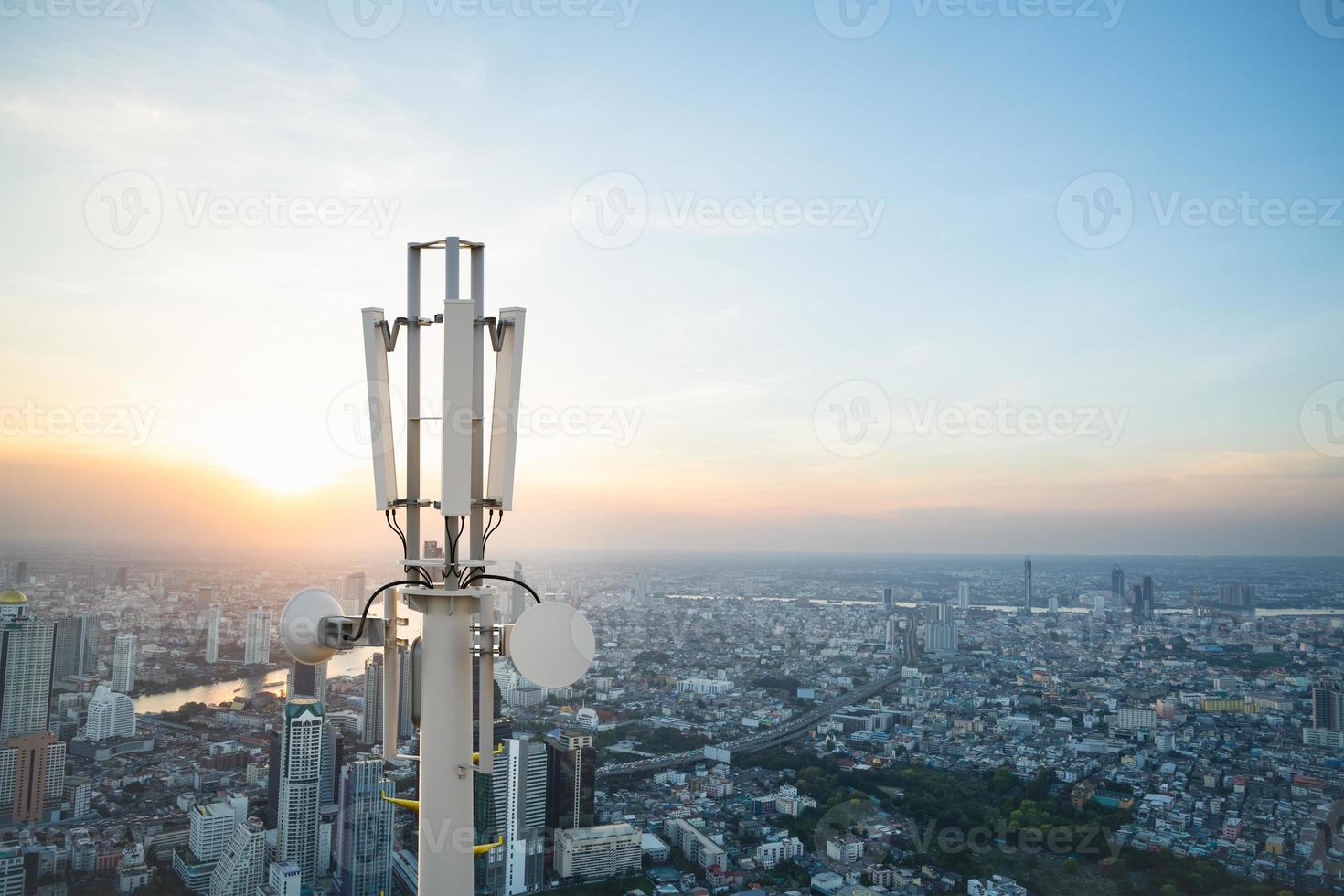 Telecommunication tower with 5G cellular network antenna on city background photo