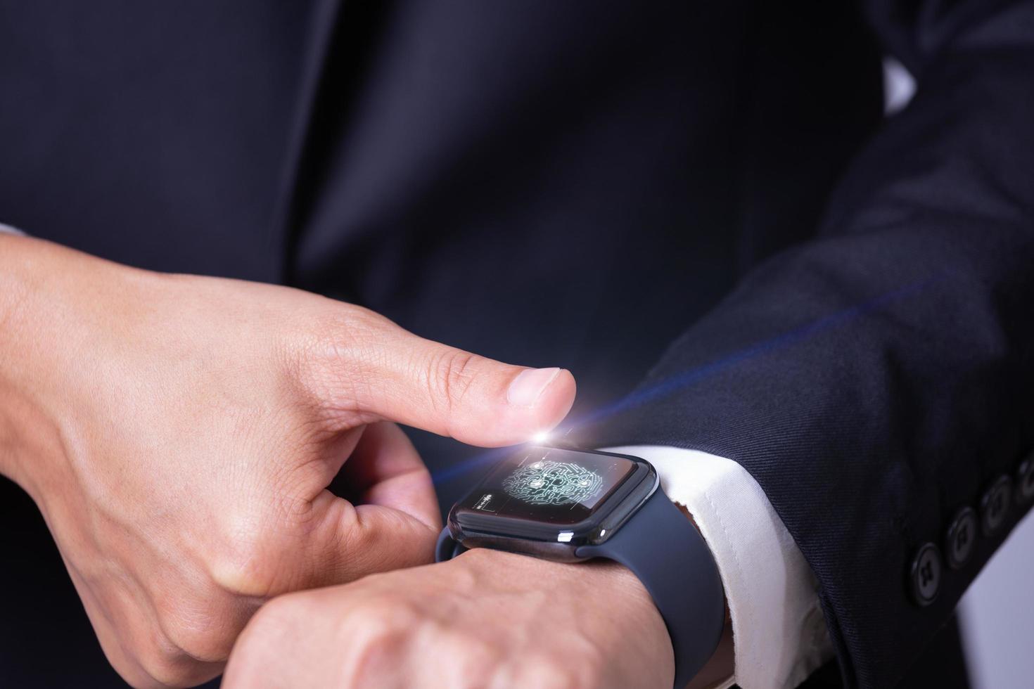 Businessman scanning fingerprint on smart watch for access his another device, Future technology concept photo